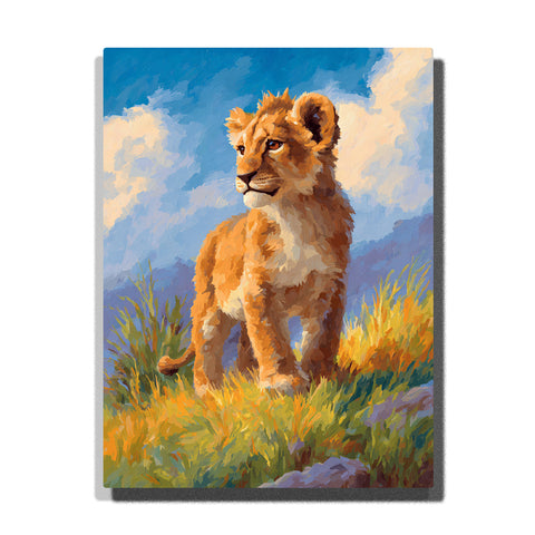 Lion cub standing in sunlit meadow grass with golden-brown fur, cream chest, blue sky, white clouds, and soft grassy hillside, paint by numbers wall art by PaintEasy