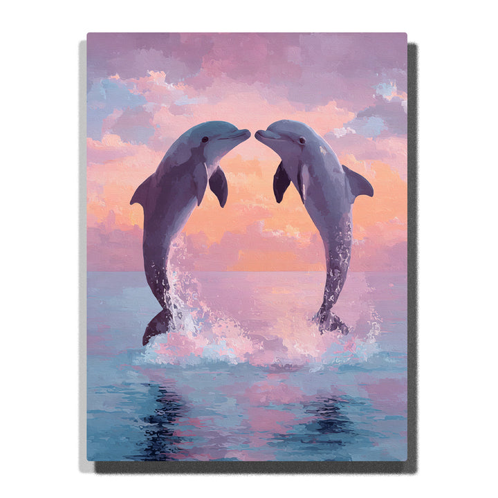 Two dolphins leaping above pink sunset water with soft peach clouds, blue ocean splashes, and gentle reflections, paint by numbers wall art by PaintEasy