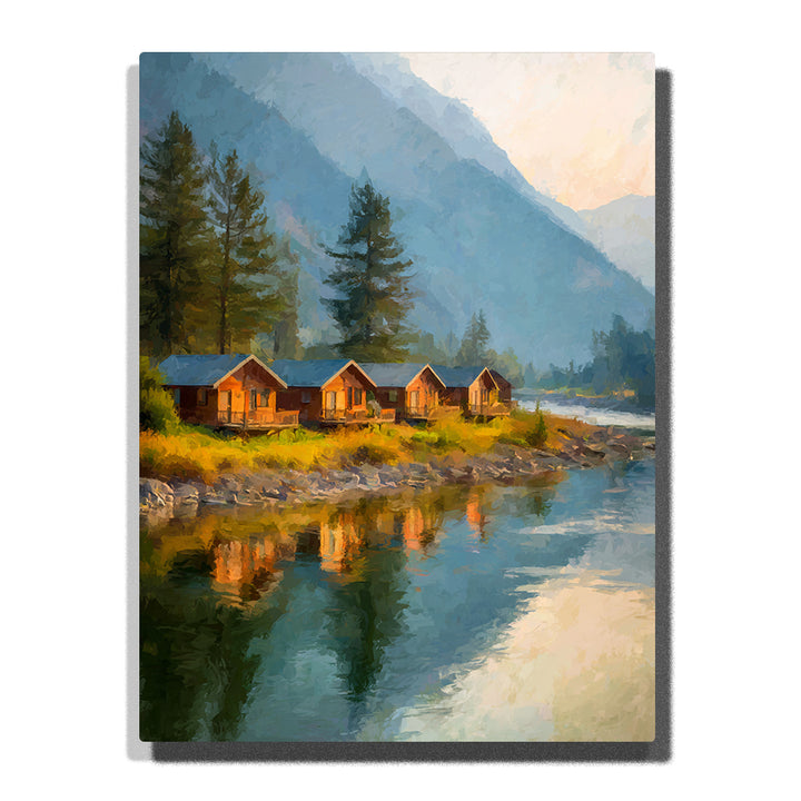 Riverside cabins with pine trees, rocky shore, calm reflections, and misty blue mountains, landscape paint by numbers wall art by PaintEasy