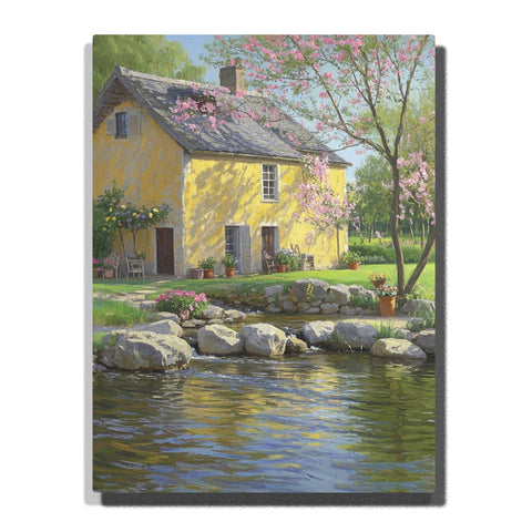 Paint by numbers kit featuring a charming yellow house by a pond with blooming trees and vibrant flowers