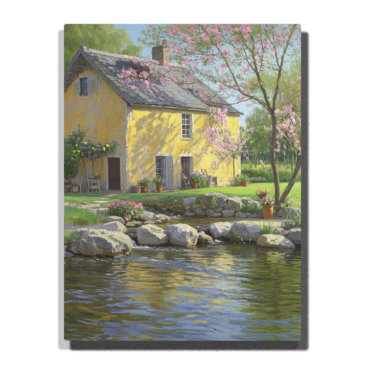 Paint by numbers kit featuring a charming yellow house by a pond with blooming trees and vibrant flowers