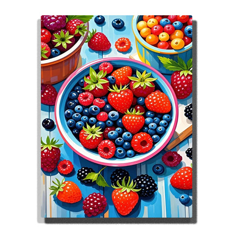 Top-down berry bowls on a blue table, featuring blueberries, strawberries, raspberries, blackberries, green leaves, scattered berries, and bright summer colors.