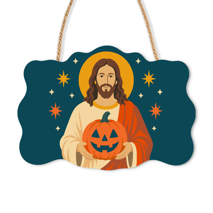 Jesus holding a grinning pumpkin against a teal starry background on a wooden sign