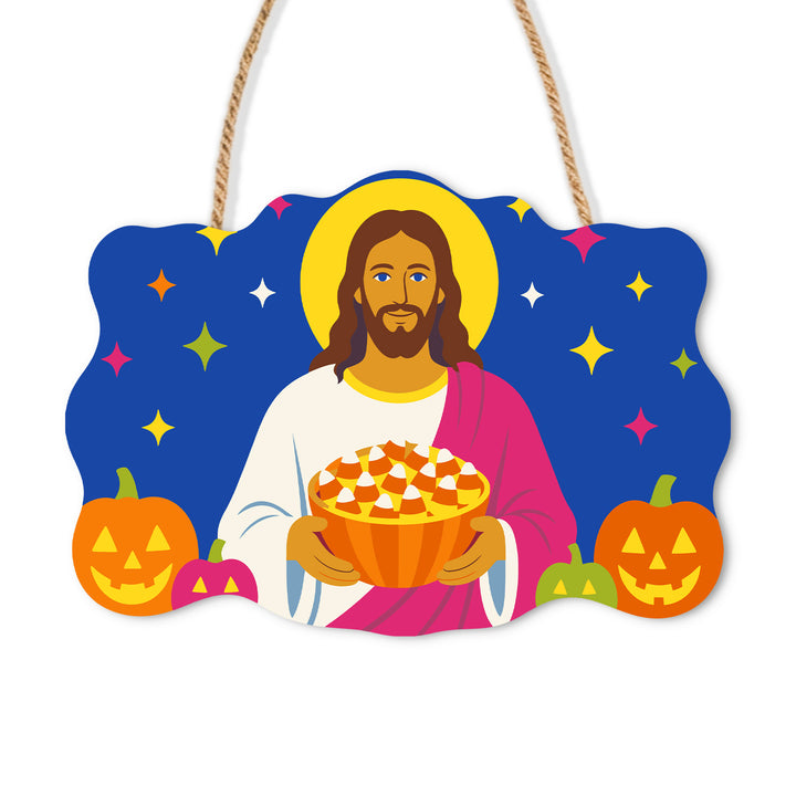 Jesus holding candy corn between grinning jack-o-lanterns against a blue sky