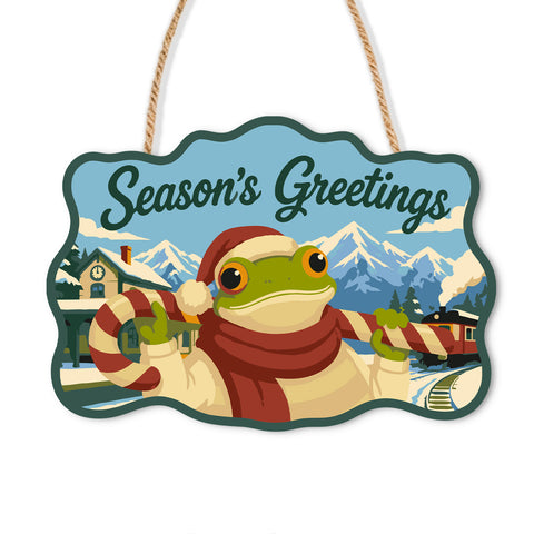 Frog in a scarf with a train and snowy mountains on a Christmas wooden door sign