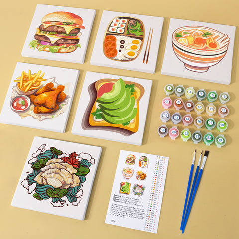 Six mini paint by numbers canvases arranged in a set, each featuring a different food illustration including a burger stack, Japanese bento box, noodle soup bowl, fried chicken with fries, avocado toast, and dumpling dish, all designed in a clean flat illustration style with bold colors and simplified shapes.