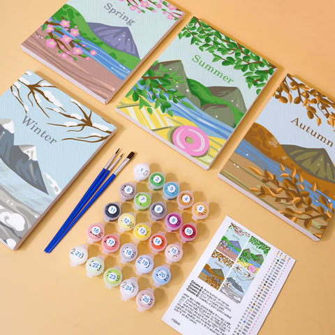 Four mini paint by numbers canvases arranged in a set, each depicting a different season landscape: spring with cherry blossoms, summer with green mountains and lake, autumn with golden leaves, and winter with snowy mountains and icy rivers. Each artwork uses a clean flat illustration style with simple shapes and soft seasonal color palettes.